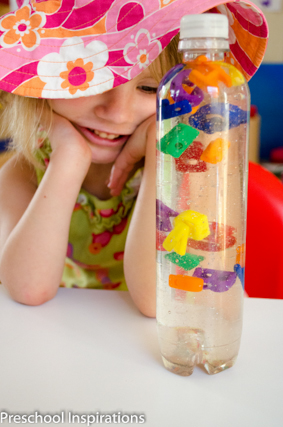 A preschooler enjoys looking at her alphabet sensory bottle and watching the letters float down