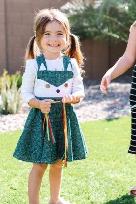 A smiling girl wearing dancing ribbons on her wrist