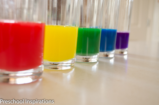 rainbow colored liquid watercolors lined up in small glasses