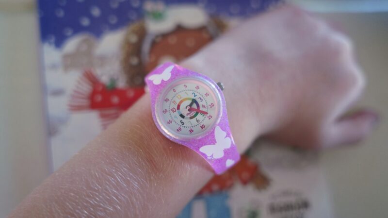 a watch designed to teach time with a butterfly band on a young girls' wrist