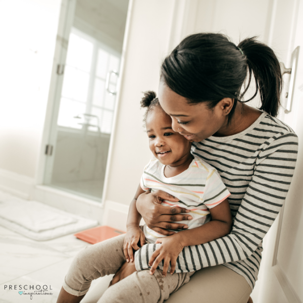 a mother sits with her toddler in the bathroom